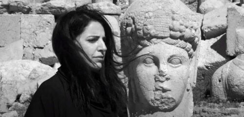 Vinden blåser i Bejan Maturs hår. I bakgrunden en staty