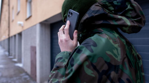 Ung maskerad kille talar i mobiltelefon