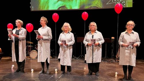 Fem kvinnor i rockar med röda ballonger