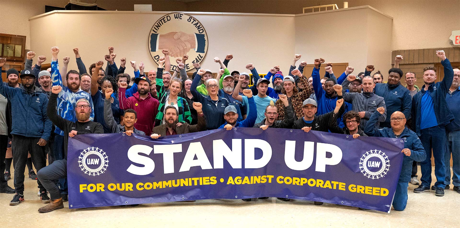 UAW-medlemmar håller upp banderoll med texten "stand up"