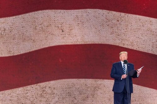 Donald Trump talar framför stor USA-flagga